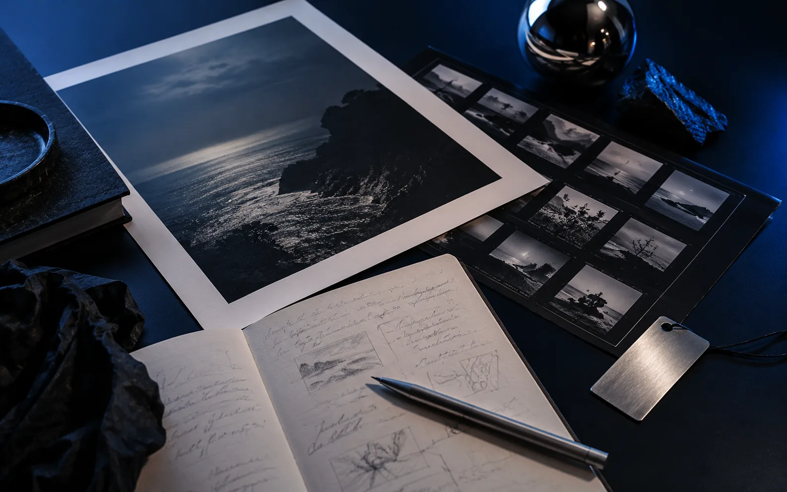 Conceptual still life of photographic work, notes, and a metal proof tag